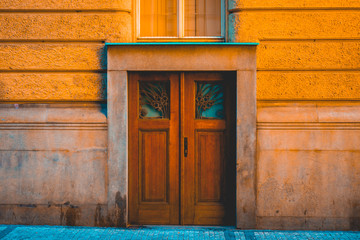 Double wooden door in colorful orange building