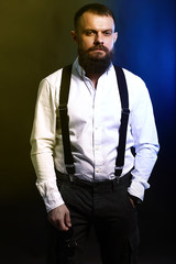 close up portrait , model, man, young handsome man with big beard on black yellow and blue background 