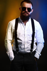 close up portrait , model, man, young handsome man with big beard on black yellow and blue background 