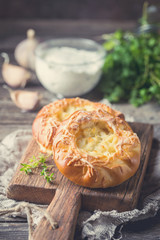 Fresh homemade open patties with cheese. Traditional Russian yeast pastry, round buns, curd tart. Buns with cottage cheese. Rustic style. Wooden background