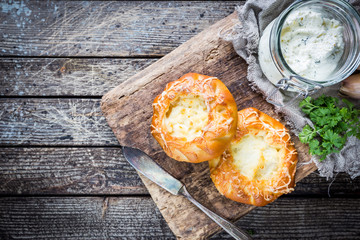 Fresh homemade open patties with cheese. Traditional Russian yeast pastry, round buns, curd tart. Buns with cottage cheese. Rustic style. Wooden background, top view