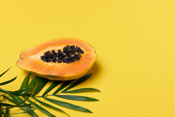 Half fresh ripe papaya on yellow background