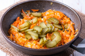 onion rings and carrots stew in a hot pan, close-up