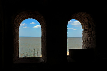 Old arched castle windows with a view on sea