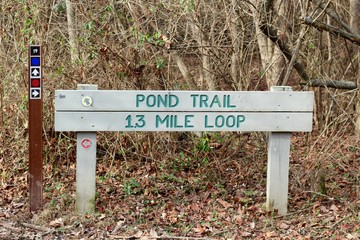 A close view of the old wooden trail sign in the park.