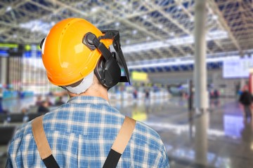 Young man in uniform and yellow helmet at work