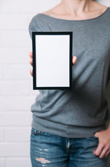 A woman holding a black frame in her hands. Template for design or text