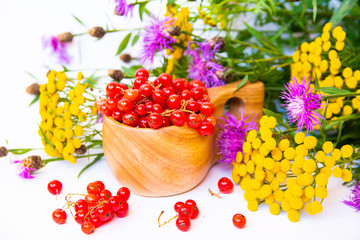 Red currant, wooden kuksa and flowers