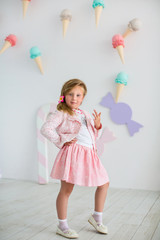 Beautiful young girl on background of large ice cream on wall