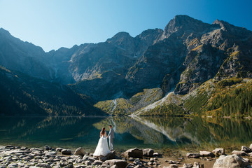 Wedding couple walking near the lake in Tatra mountains in Poland. Morskie Oko. Beautiful summer day © WellStock