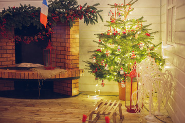 Beautiful decorated Christmas tree near the fireplace.