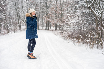 woman walking in winter forest wonderland on snowy day