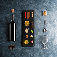 Mulled wine recipe ingredients and kitchen accessories, bottle of red wine, cinnamon, anise stars,...