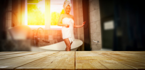 A wooden table and a girl in the bathroom with a beautiful sunset coming through the window  