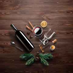 Mulled wine recipe ingredients and kitchen accessories, bottle of red wine, cinnamon, anise stars,...