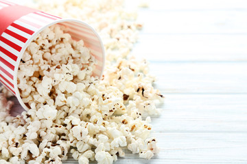 Popcorn in striped bucket on wooden table