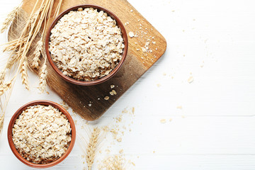 Oatmeal in bowls on white wooden table