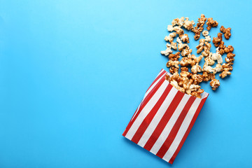 Caramel popcorn in paper bag on blue background