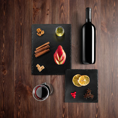 Mulled wine recipe ingredients and kitchen accessories, bottle of red wine, cinnamon, anise stars,...