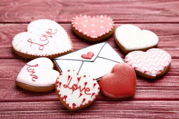 Obraz na płótnie Canvas Valentine day heart and envelope shaped cookies on red wooden table