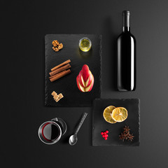 Mulled wine recipe ingredients and kitchen accessories, bottle of red wine, cinnamon, anise stars,...
