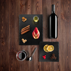 Mulled wine recipe ingredients and kitchen accessories, bottle of red wine, cinnamon, anise stars,...