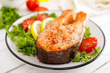 Salmon fish steak grilled and fresh vegetable salad with tomato and lettuce. Healthy food. Top view