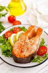 Salmon fish steak grilled and fresh vegetable salad with tomato and lettuce. Healthy food. Top view