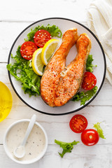Salmon fish steak grilled and fresh vegetable salad with tomato and lettuce. Healthy food. Top view