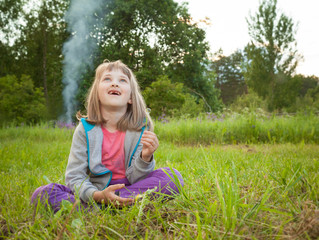 Adorable preschooler girl playing in a summer park