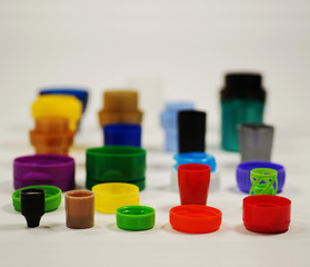 Different shaped and colored caps from bottles, containers, creams and pastes. Recycling.