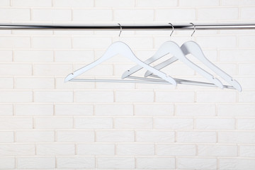Wooden hangers hanging on brick wall background