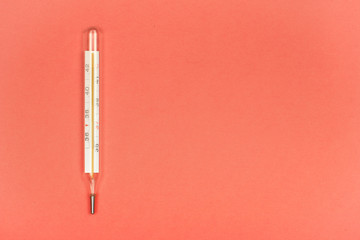 Medical mercury thermometer, Living Coral, trendy color 2019 background.  Free space for text.