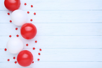 Colorful balloons with paper stars on wooden table