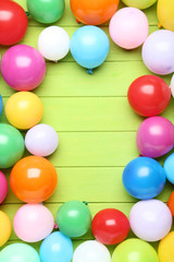 Colorful balloons on green wooden table