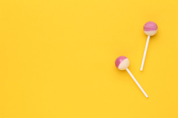 Sweet lollipops on yellow background