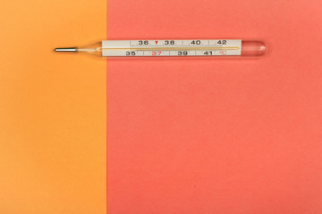 Medical mercury thermometer, Living Coral, trendy color 2019 background.  Free space for text.