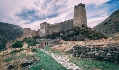Old castle in the state among the mountains under a stormy sky