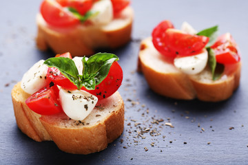 Bruschetta with mozzarella, tomatoes and basil leafs