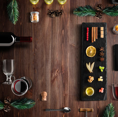 Mulled wine recipe ingredients and kitchen accessories, bottle of red wine, cinnamon, anise stars,...