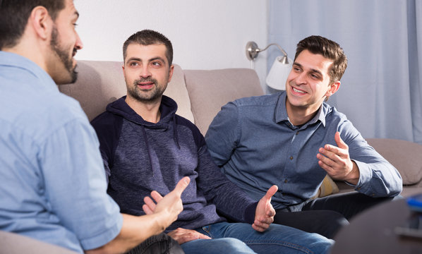 Three males having fun talking on couch