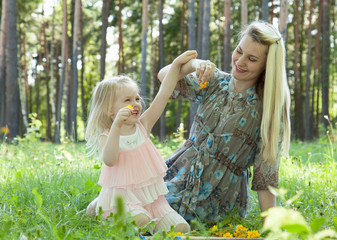 Obraz premium Playful little girl having fun with her pregnant young mother