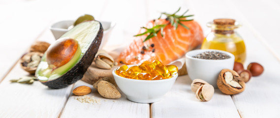 Selection of healthy unsaturated fats, omega 3 - fish, avocado, olives, nuts and seeds