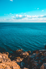 some orange colored rocks with darken blue sea
