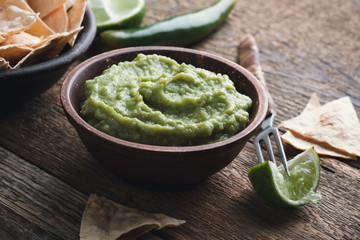 Fresh guacamole dip with lime juice in ceramic bowl