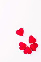 Concept of flower made of heart shaped red jelly sweets on isolated white background. Top view. Copy space.