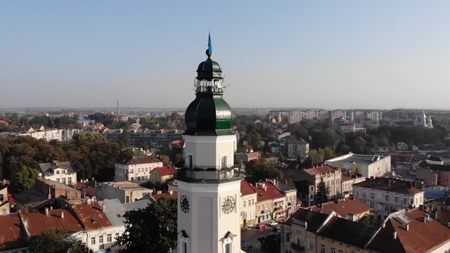 Tower of City Hall of Drohobych city with flag of Ukraine. Smooth pan around tower, cityscape