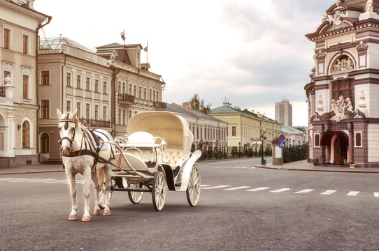 Emoty white carriage with white horse waits for tourists in central square, Kazan