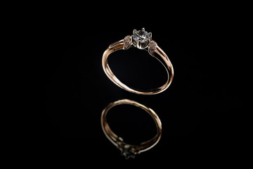 Gold ring with reflection on the mirror black background