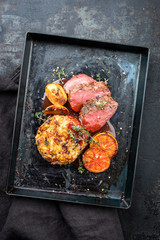 Traditional saddle of venison with Swiss rösti, quince and orange slices in game red wine sauce as...